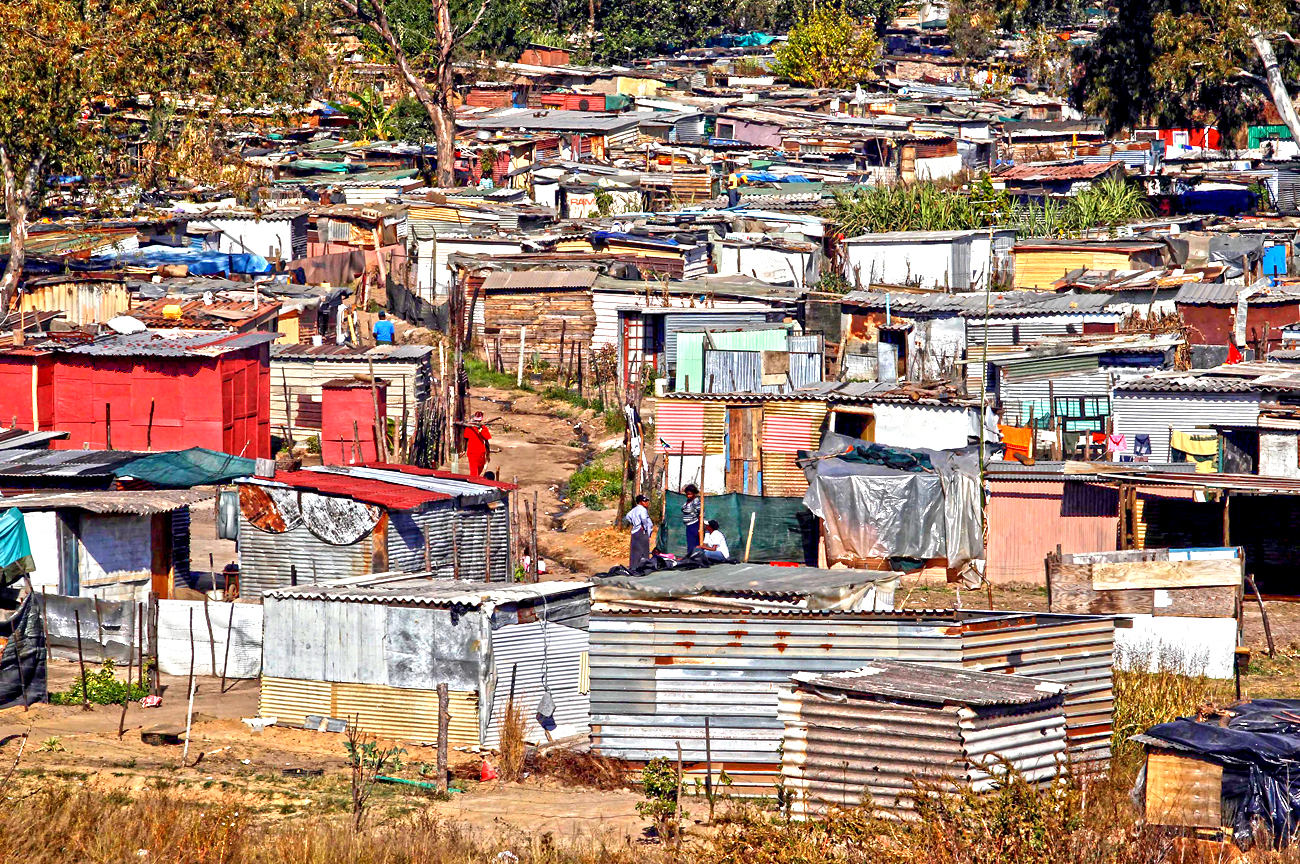 People chat in a slum in the outskirts of Johannesburg