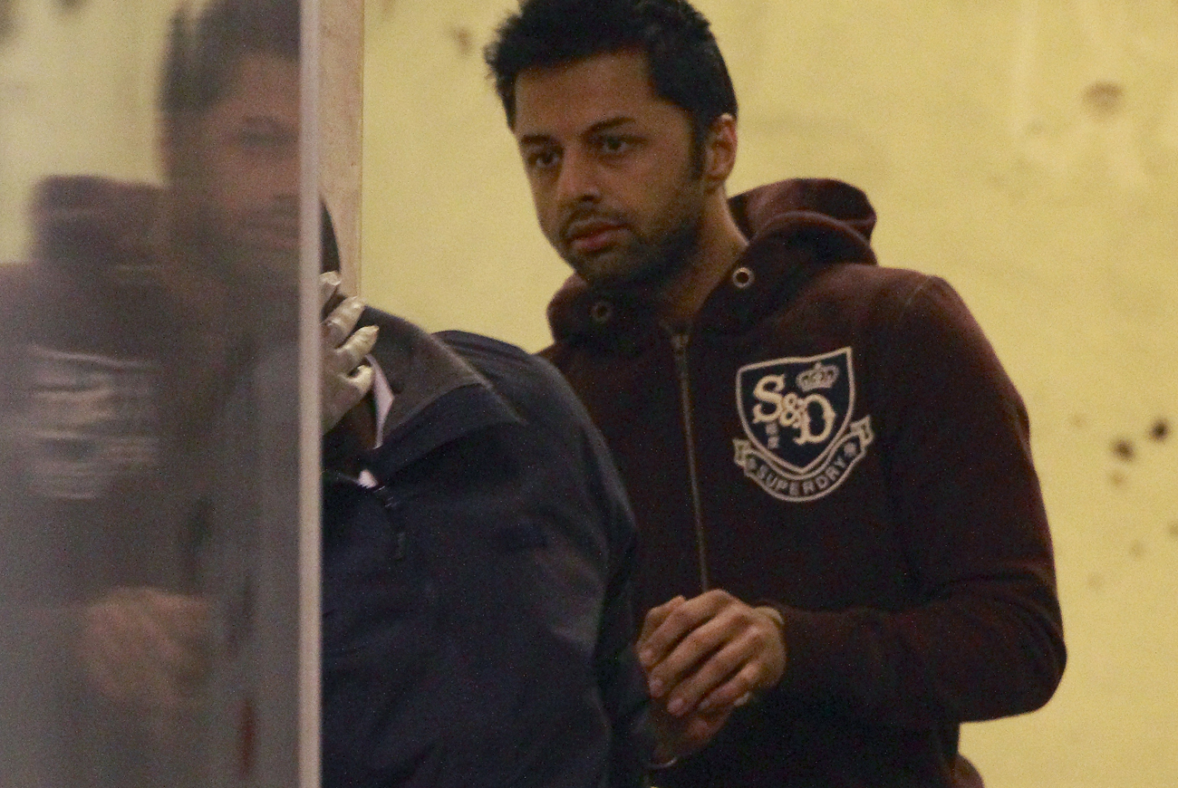 Businessman Shrien Dewani is led to a prison van by a warder at Westminster Magistrates Court in central London