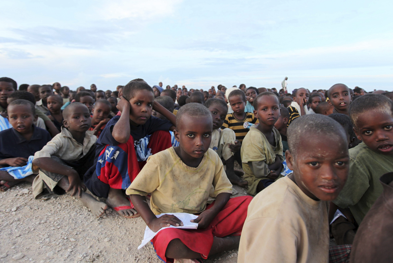 Internally displaced children wait to receive food rations from al-Qaeda at the Ala-yasir IDP camp for al Shabaab militias in Lower Shabelle