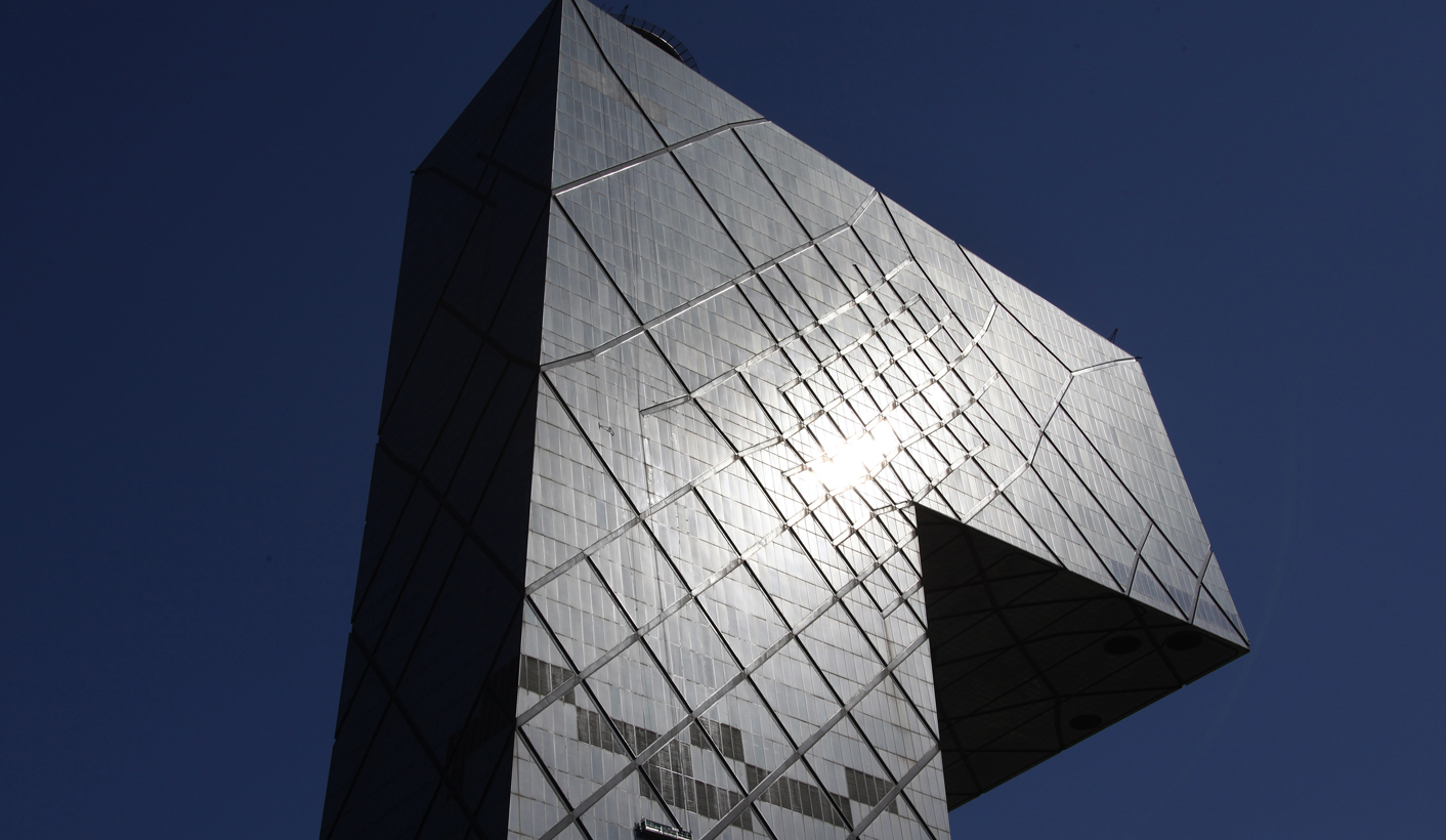 Window cleaners stand on a platform hanging from the front of the CCTV building in central Beijing