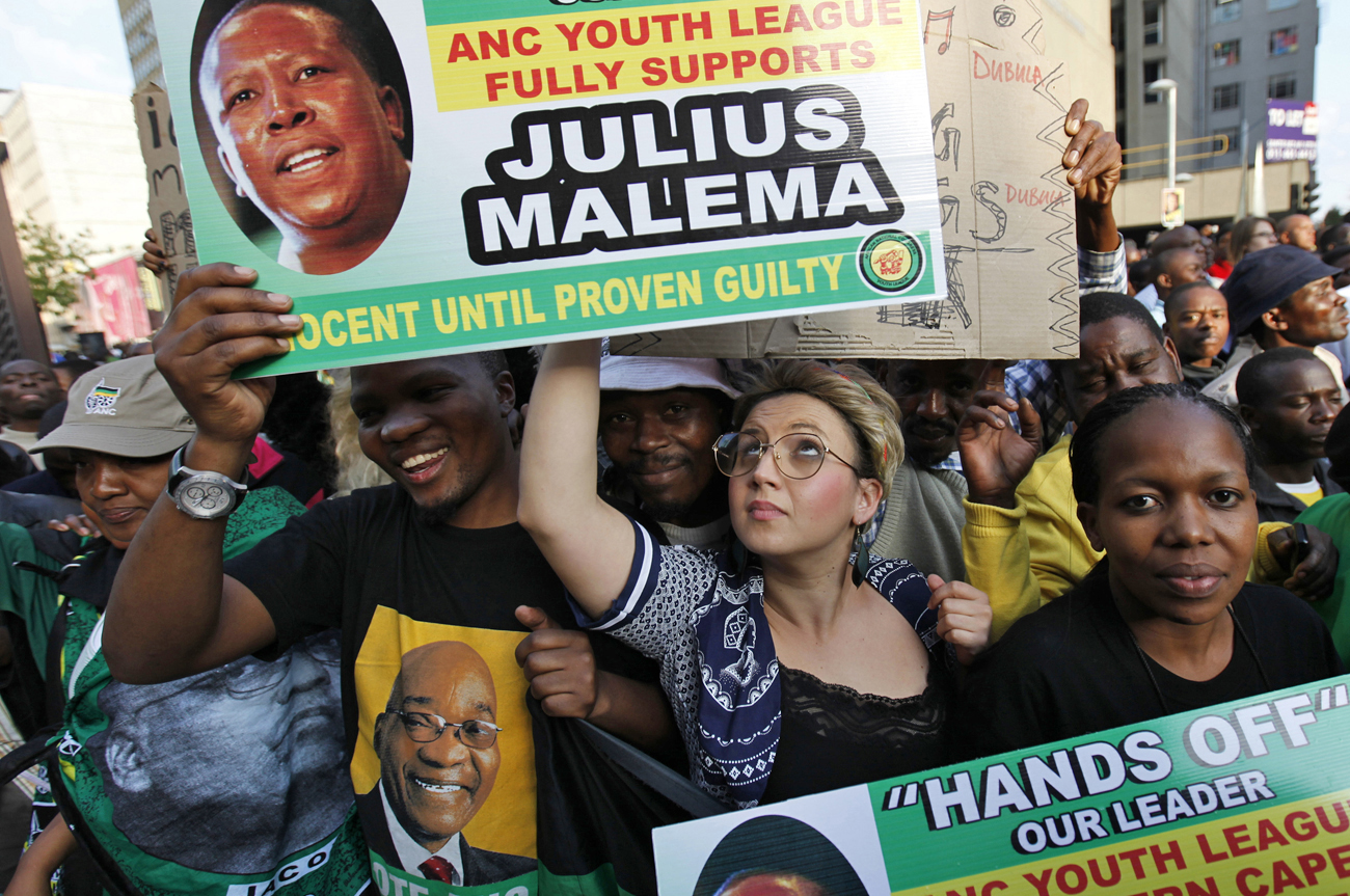 Supporters of ANCYL President Malema hold placards during his appearance at the Johannesburg court