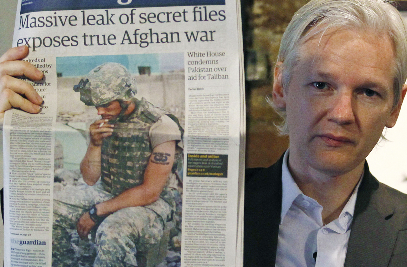 Wikileaks founder Julian Assange holds up a copy of a newspaper during a press conference at the Frontline Club in central London