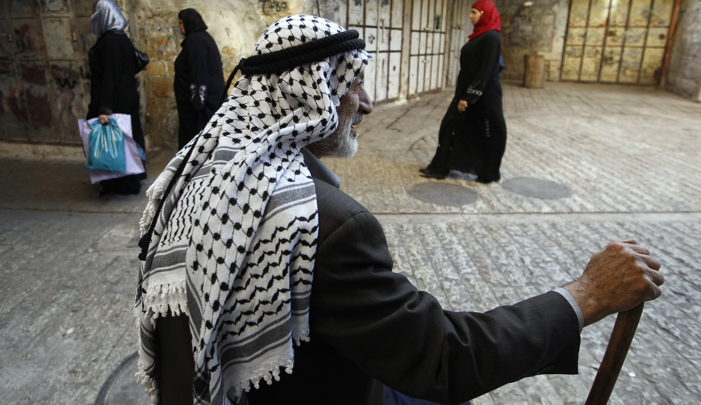 A Palestinian man wears a keffiya headdress in the West Bank city of Hebron