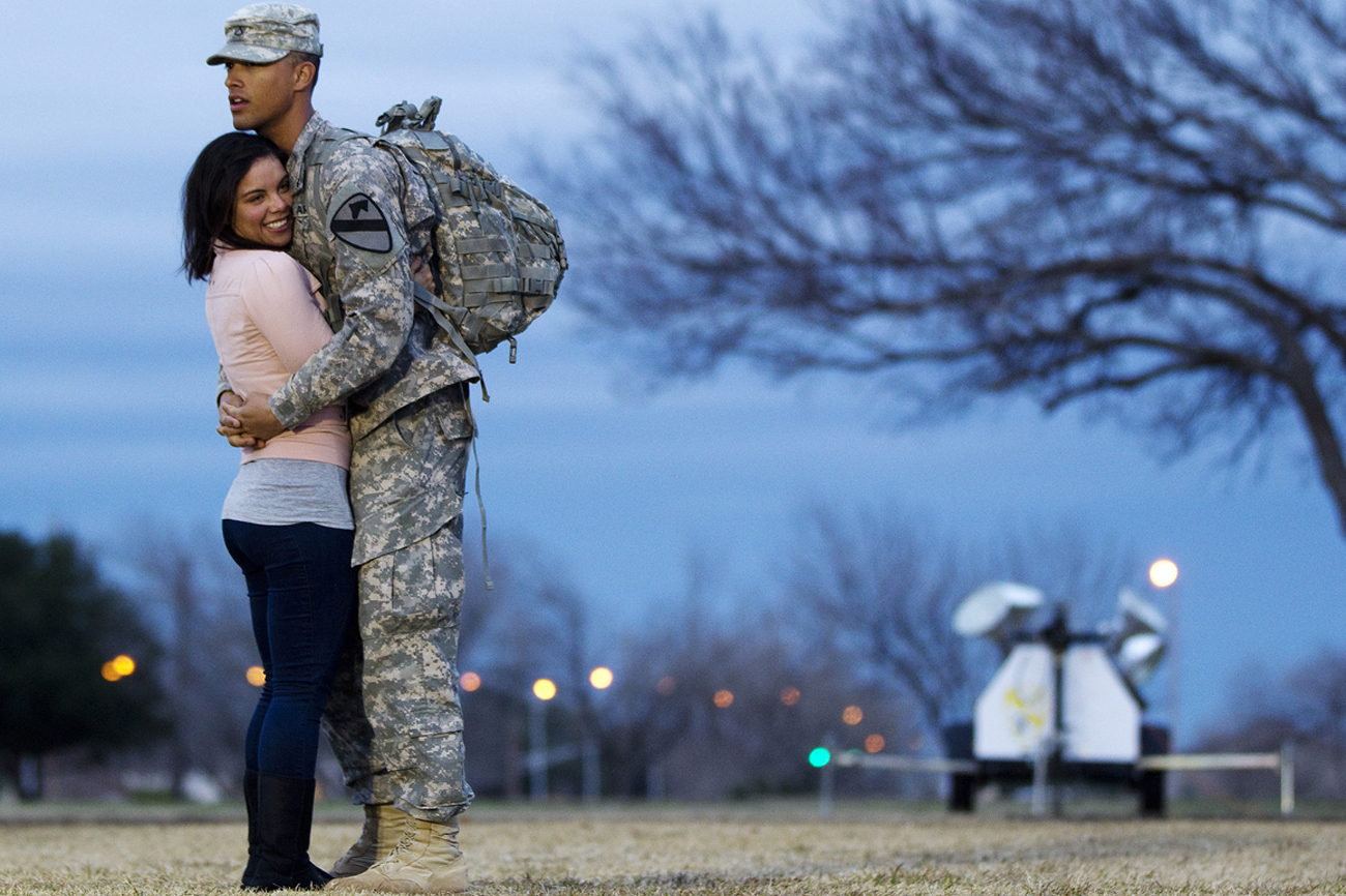 Private Devin Alderman hugs his girlfriend, Gislaine Powers, during a homecoming ceremony to welcome the unit home at Fort Hood