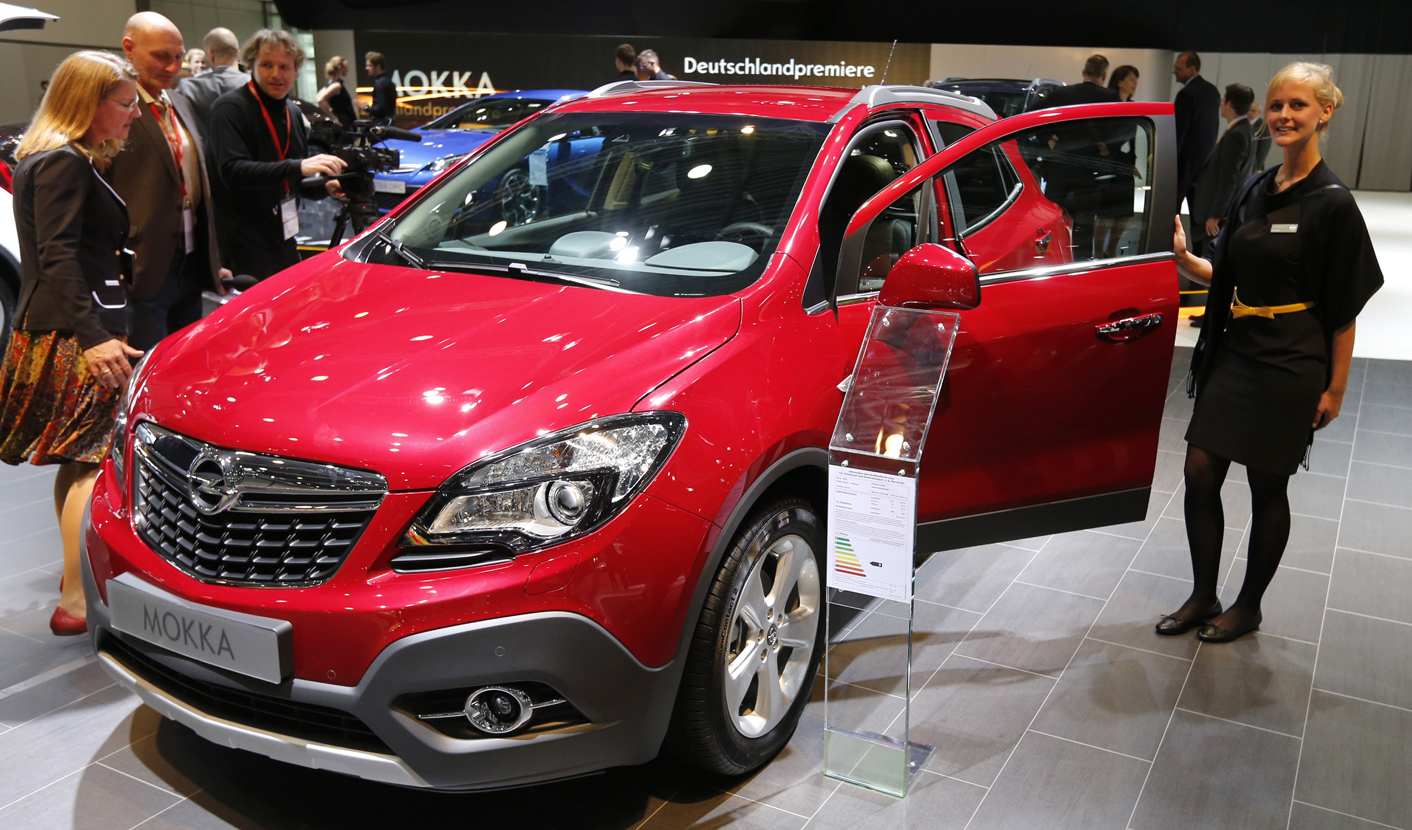 A model poses next to an Opel Mokka car at the AMI Auto Show in Leipzig