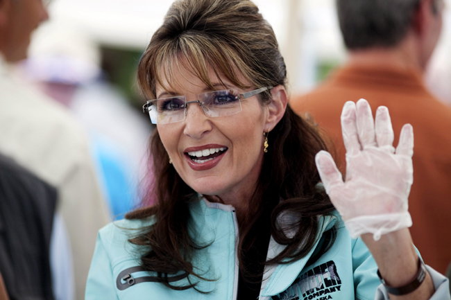 Alaska Governor Sarah Palin waves to well-wishers while serving hot dogs at the annual Governor's Picnic in Fairbanks, Alaska