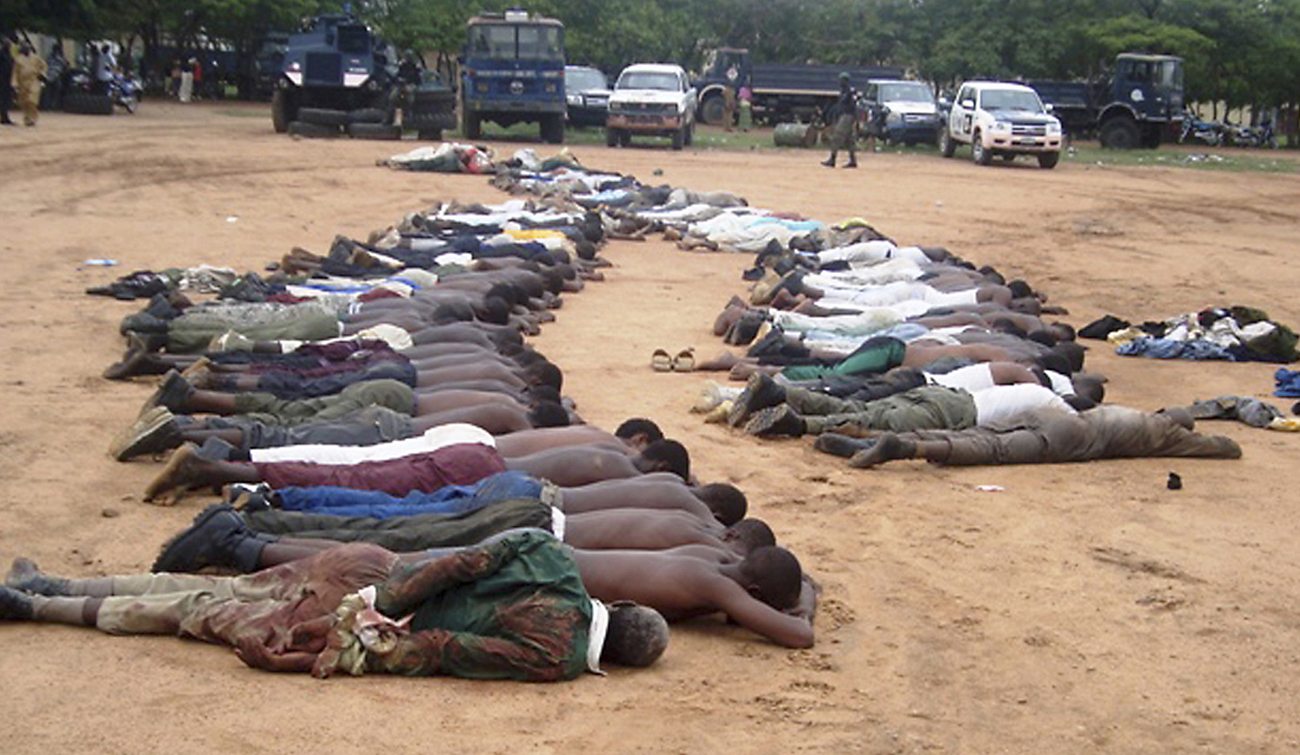 Members of an local Islamic group lie on the ground at a police station after their arrest in the northeastern city of Bauchi