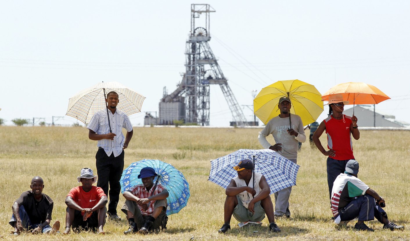 Miners wait for suspended ANC Youth League President Julius Malema to address them outside the Impala platinum mine in Rustenburg