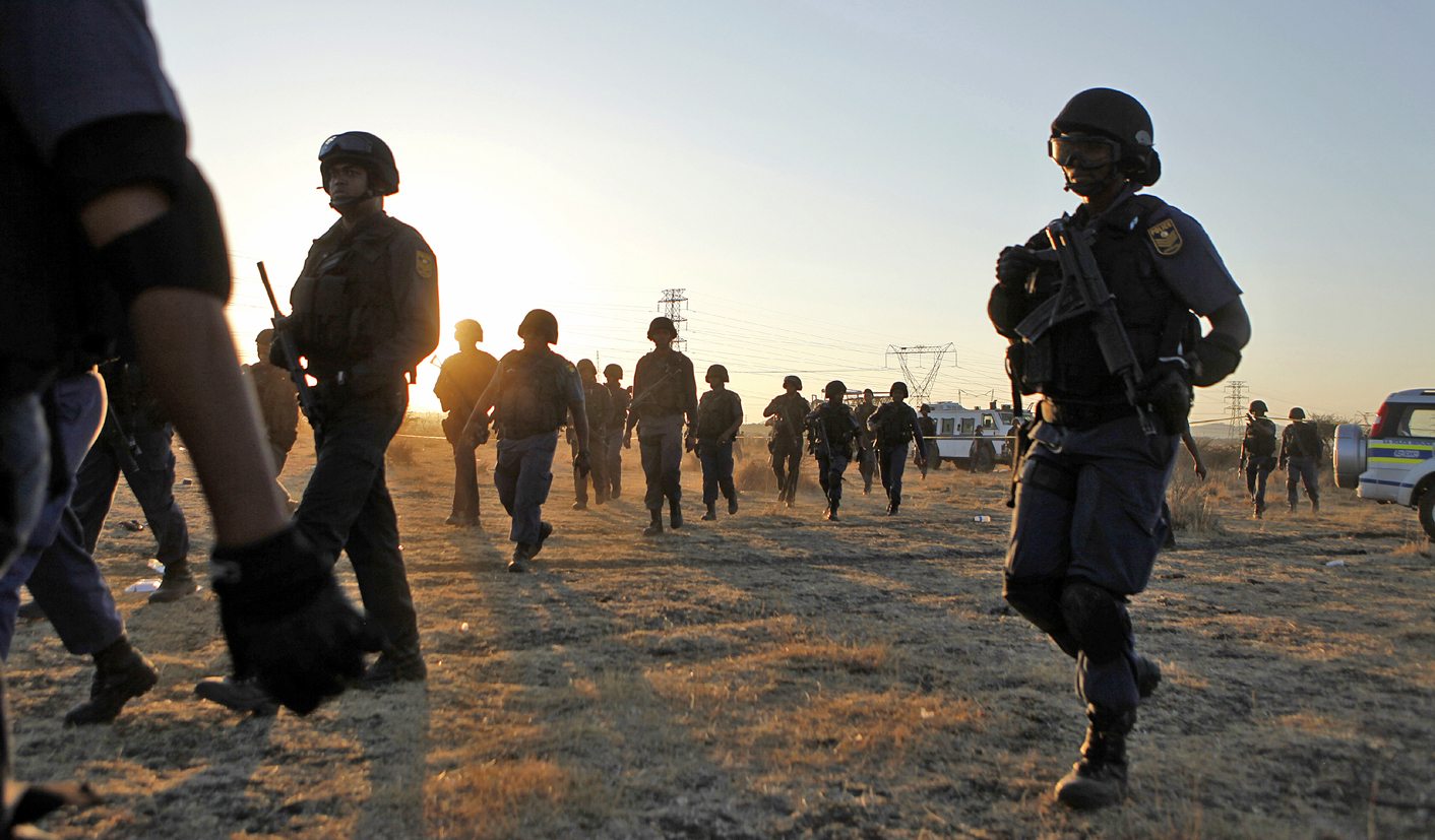 Special task force members and policemen walk back to their cars after protesting miners were shot outside a South African mine in Rustenburg