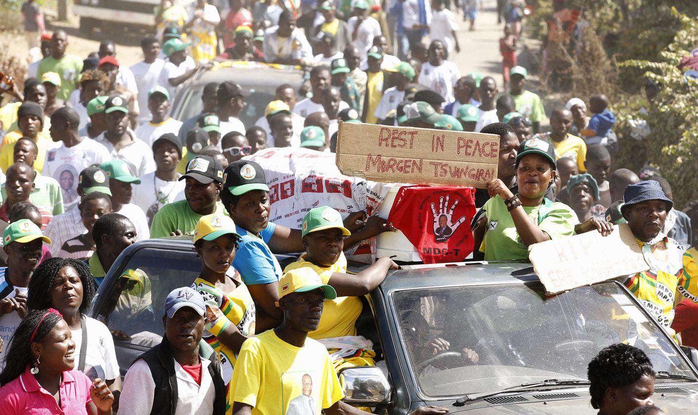 Supporters of ZANU-PF party celebrate with a coffin wrapped in a MDC flag in Mbare township, outside Harare