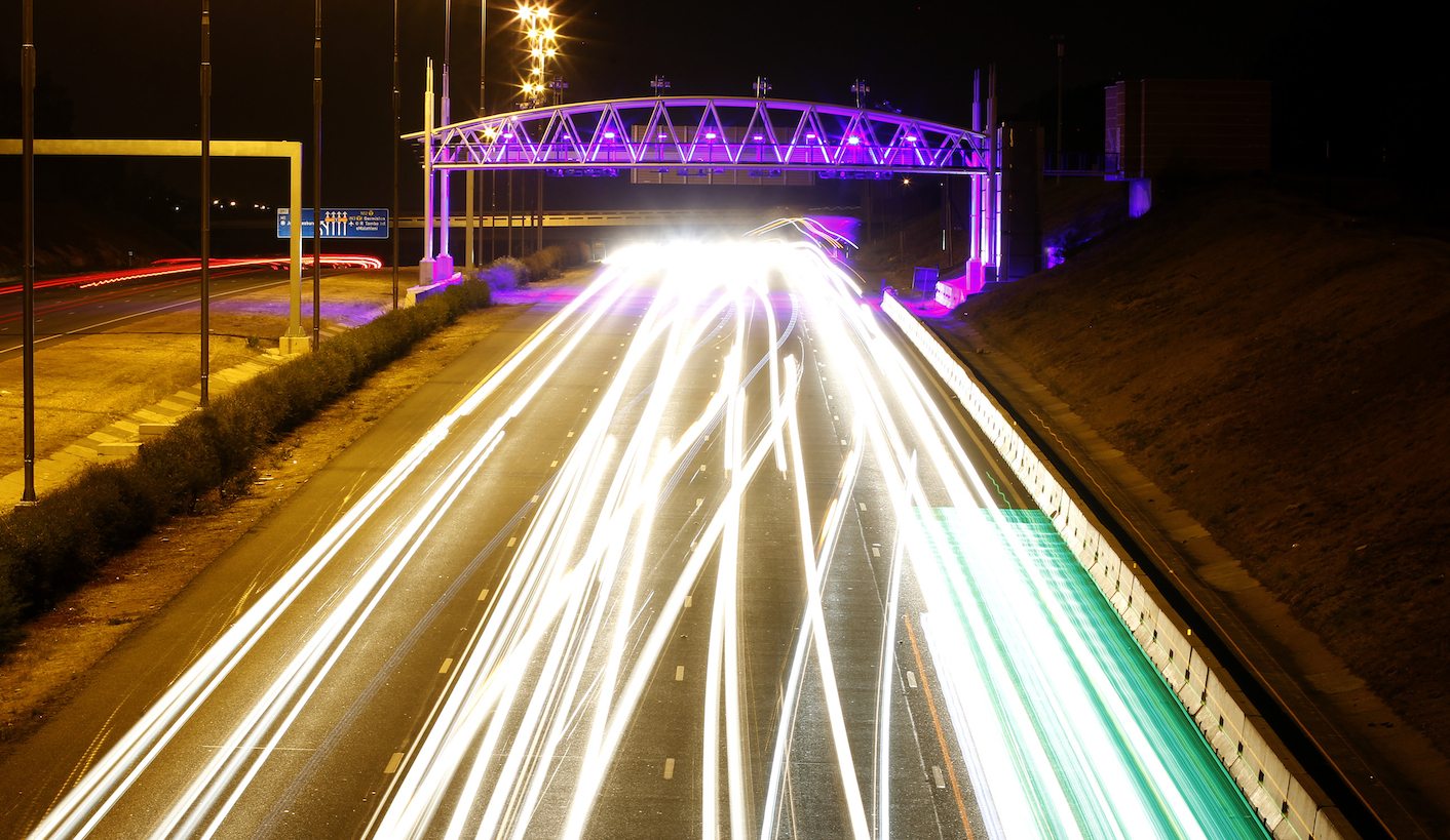 Cars drive below a road toll in Johannesburg