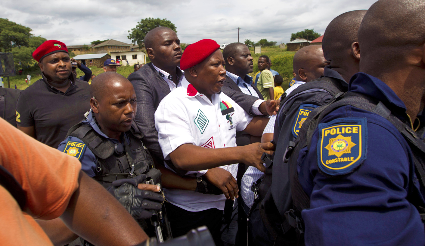 EFF leader Julius Malema is escorted by police after his car was blocked by supporters of the ANC near the homestead of South African President Zuma in Nkandla