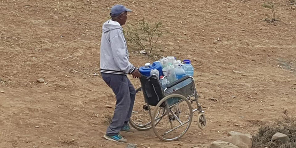 A man pushes water home in a wheelchair. (Photo: Gift of the Givers)