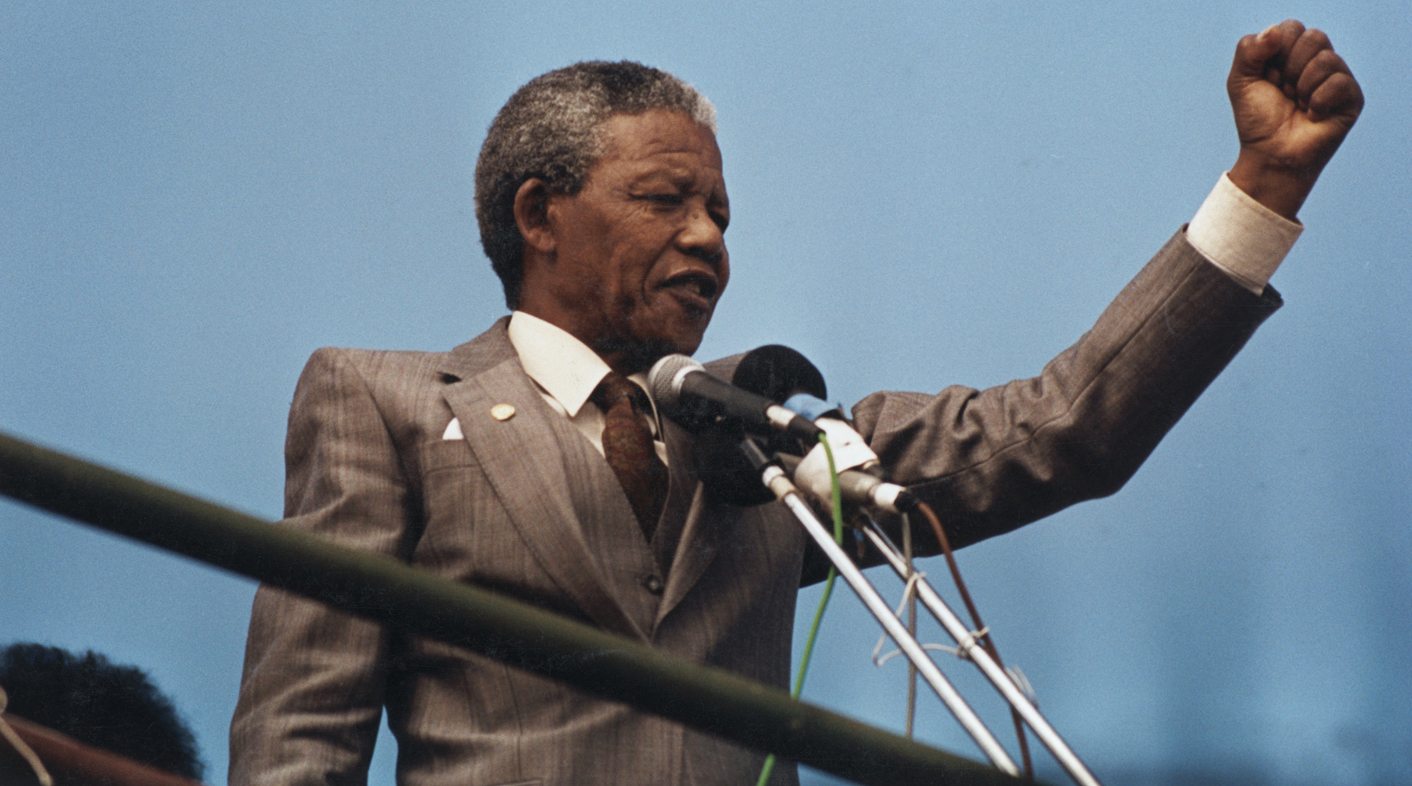 Nelson Mandela raises his fist to the crowd in Port Elizabeth