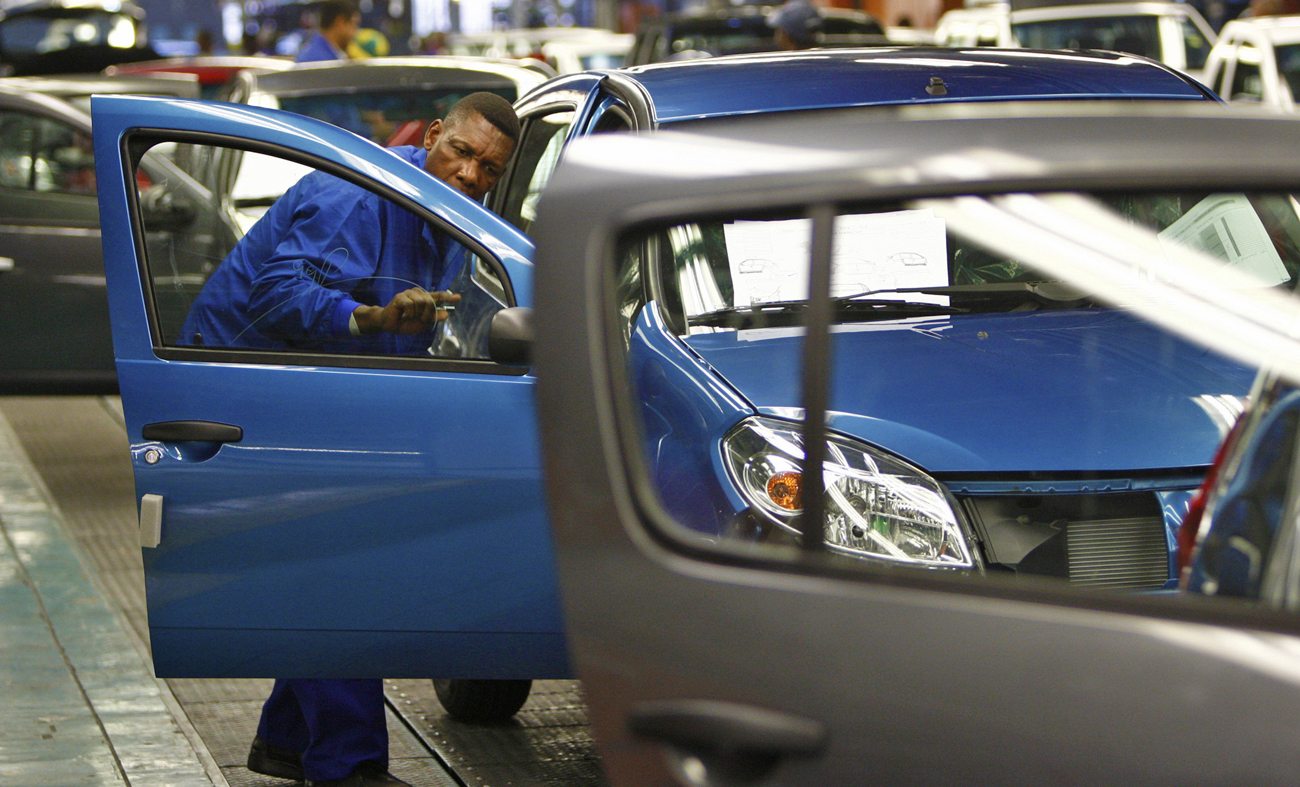 A worker inspects cars at Nissan's manufacturing plant in Rosslyn