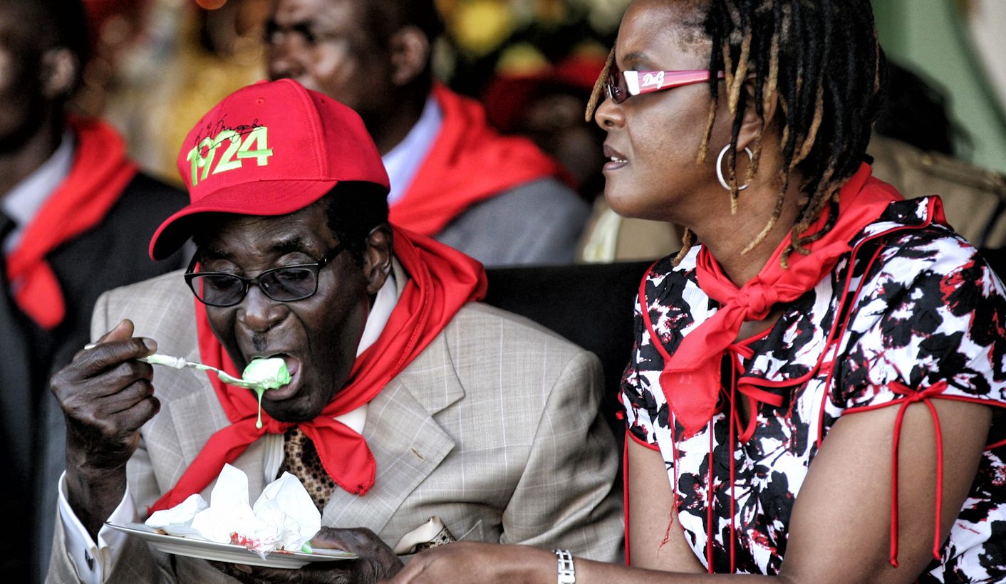Zimbabwe's President Robert Mugabe eats cake next to his wife Grace during an event marking his 89th birthday in Bindura