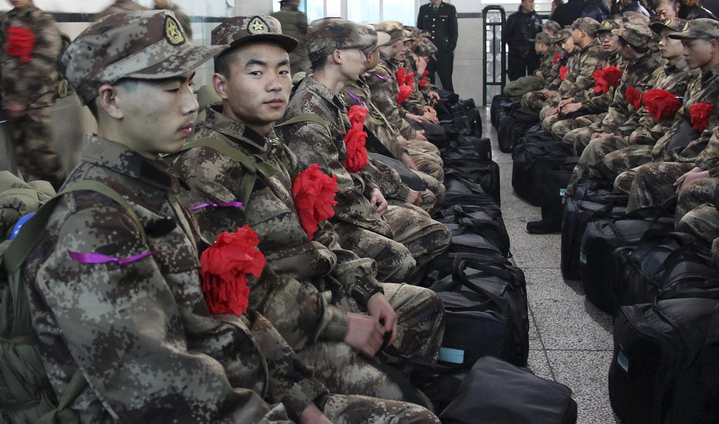 New recruits for the People's Liberation Army wait to board a train at a train station in Mayang Miao autonomous county