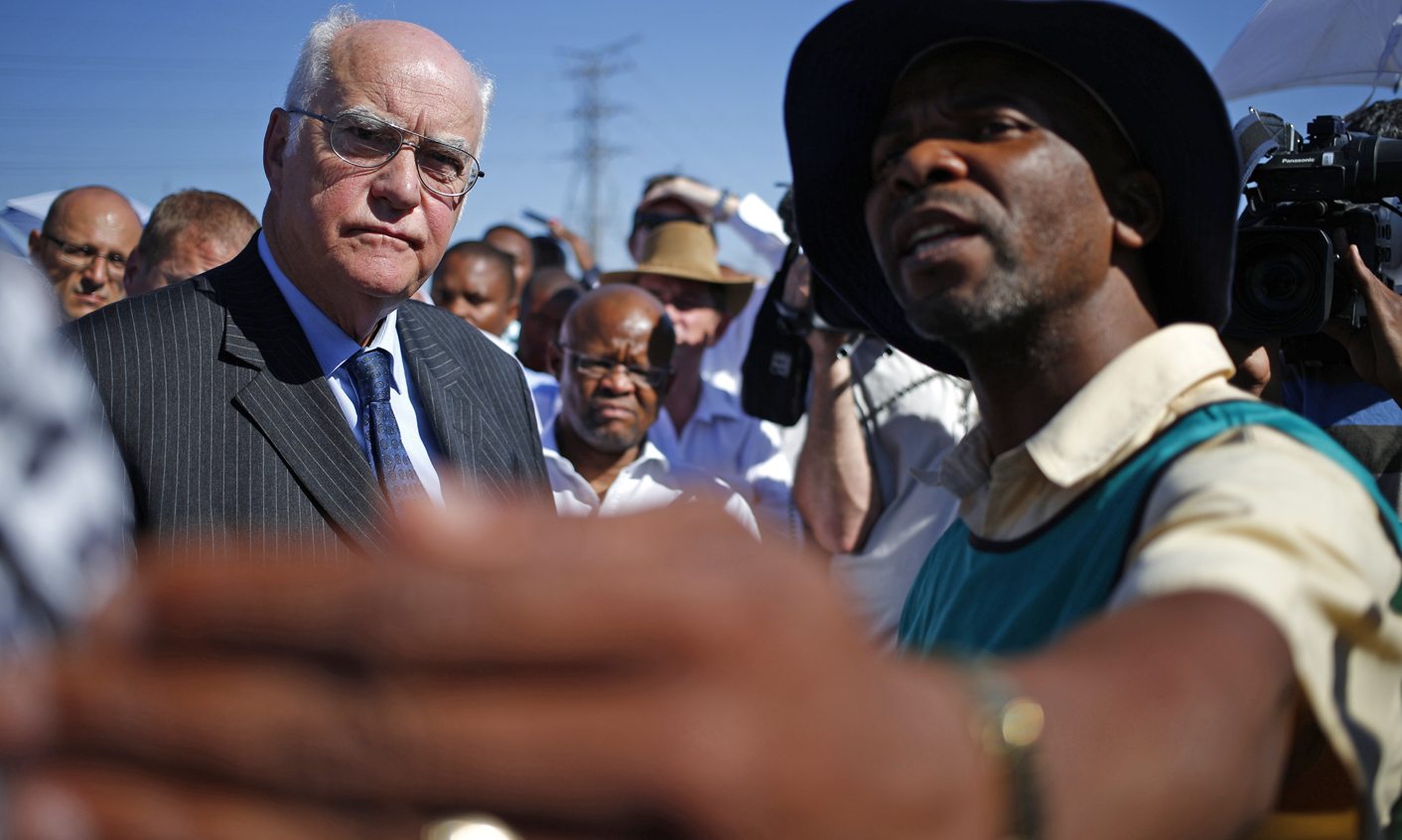 Police investigators show retired judge Ian Farlam where bodies were found during a site inspection by the judicial commission of inquiry into the shootings at Lonmin's Marikana mine