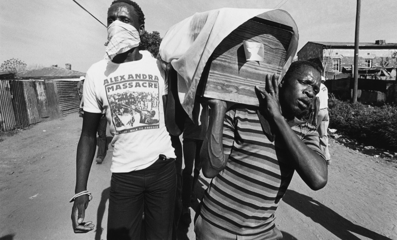 Pallbearers march in a funeral procession for one of the victims