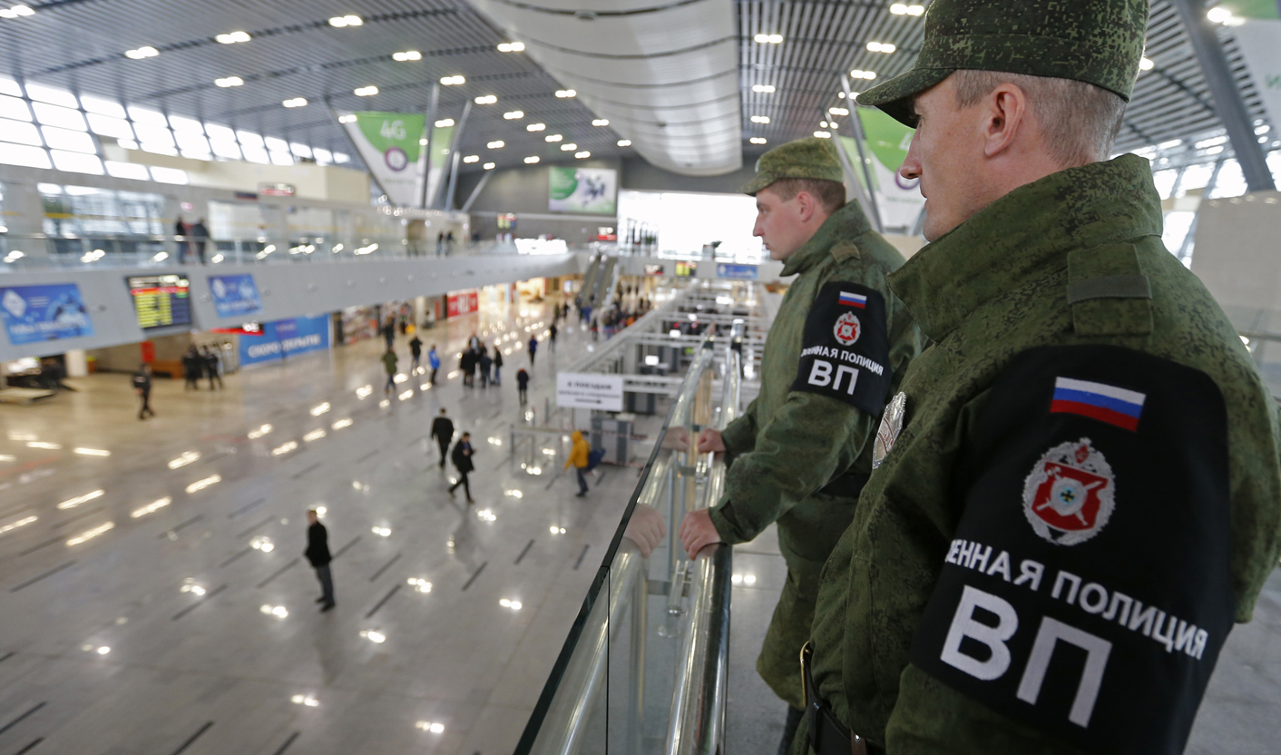 Military police officers stand guard at a train station in the Adler district of Sochi