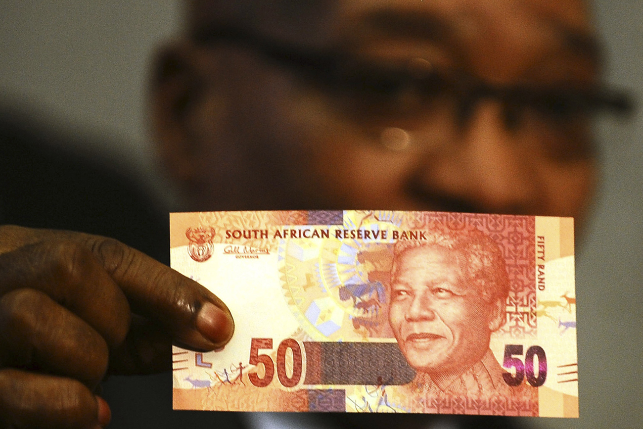 South Africa's President Jacob Zuma holds up a banknote bearing the face of former president Nelson Mandela in Pretoria