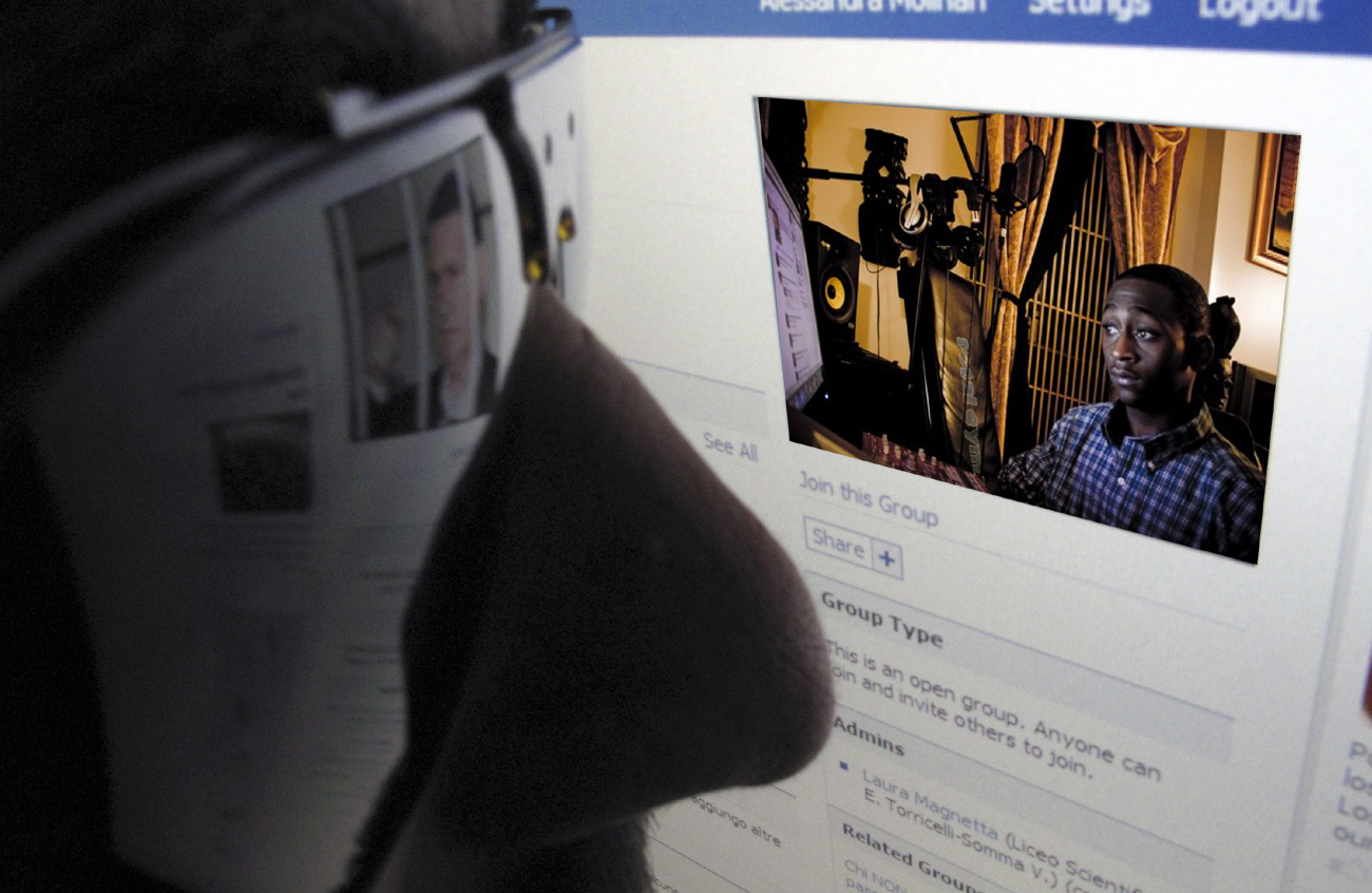 A man views a computer screen showing a Facebook fan page dedicated to Mafia chieftain Riina in Rome