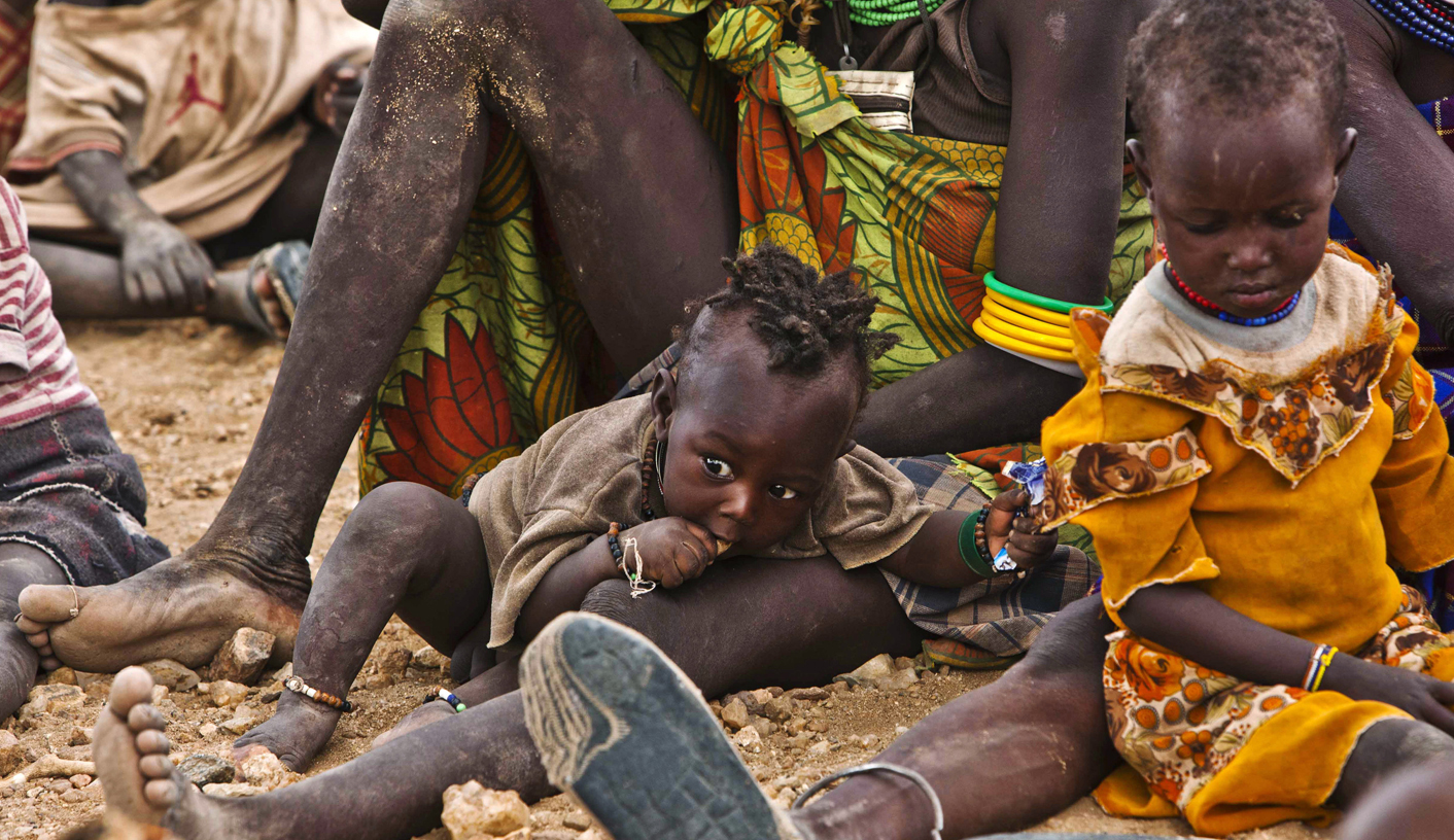 Turkana women and their children wait to receive relief food supplies near the Kakuma Refugee Camp