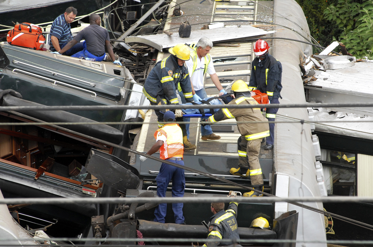 Rescue workers carry an injured man from the wreckage of a luxury passenger train that crashed in Pretoria