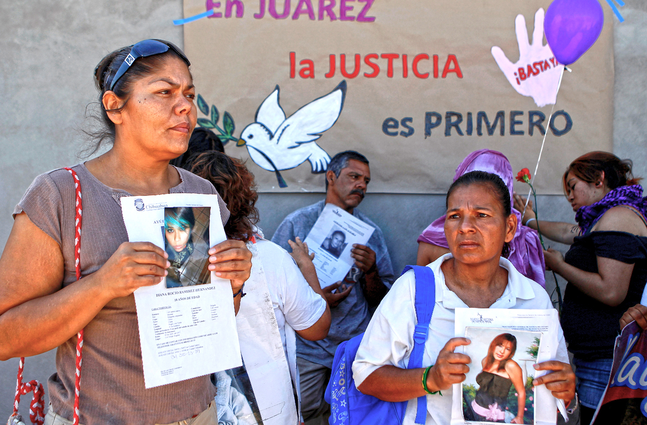 Relatives of missing women hold flyers with information about their loved ones after a rally led by Mexican poet Sicilia to support victims of feminicide in Ciudad Juarez