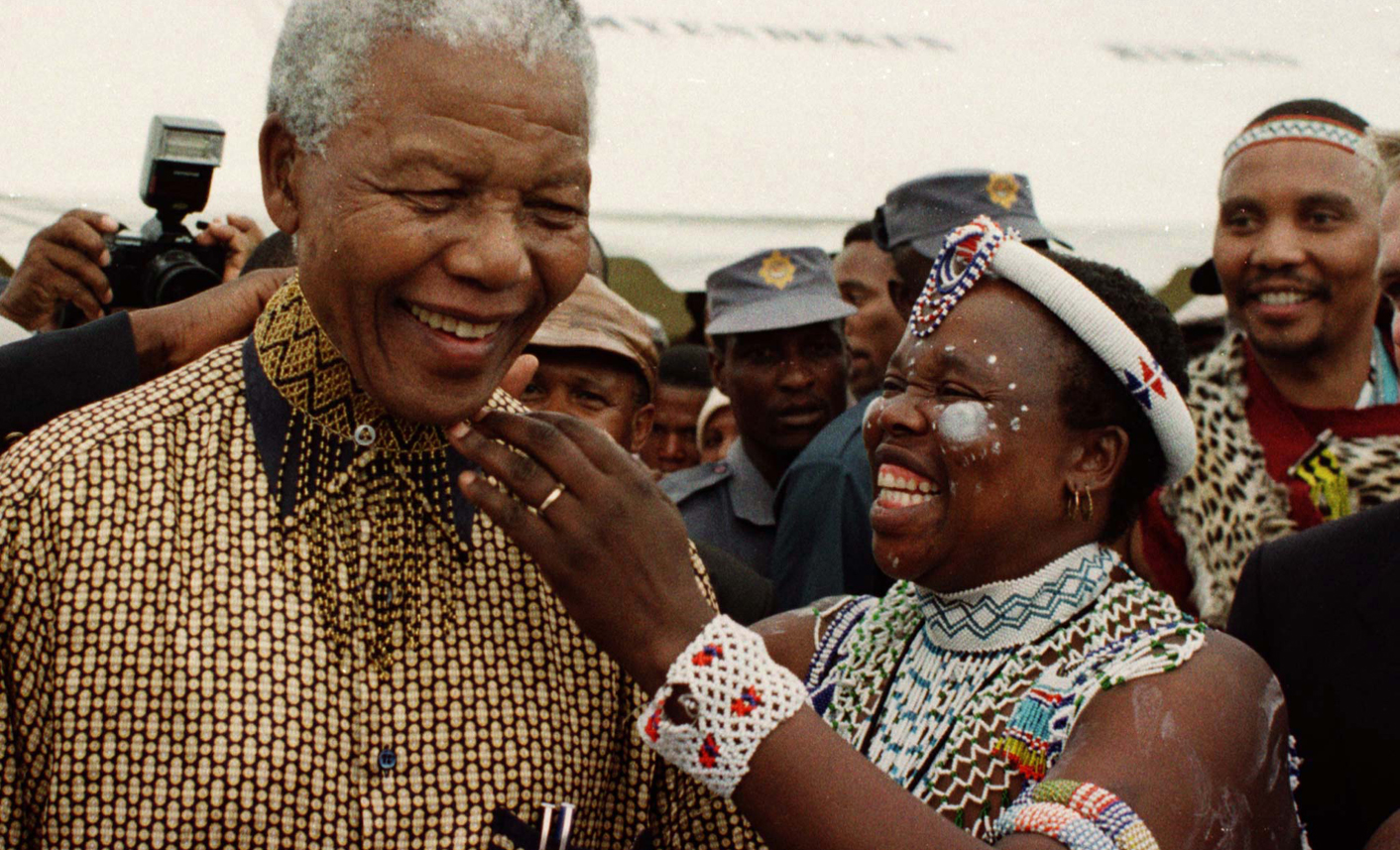 NELSON MANDELA IS ADORNED BY XHOSA WOMAN DURING INSTALLATION OF NEW CHIEF.