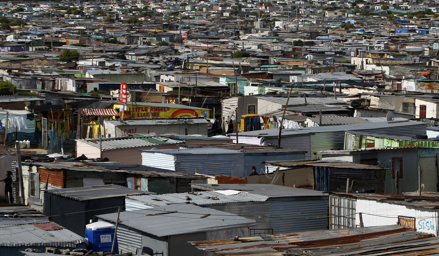 Residents walk through shacks in Cape Town's crime-ridden Khayelitsha township