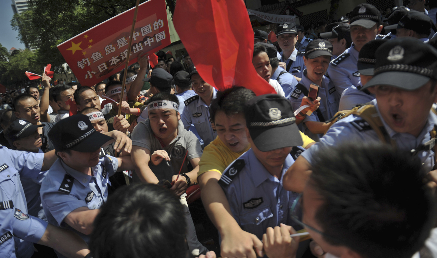 Protesters clash with policemen as they tried to break into a hotel which leads to the Japanese consulate in Guangzhou