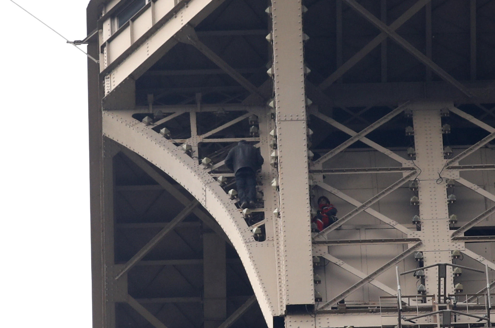 A man climbs the Eiffel Tower