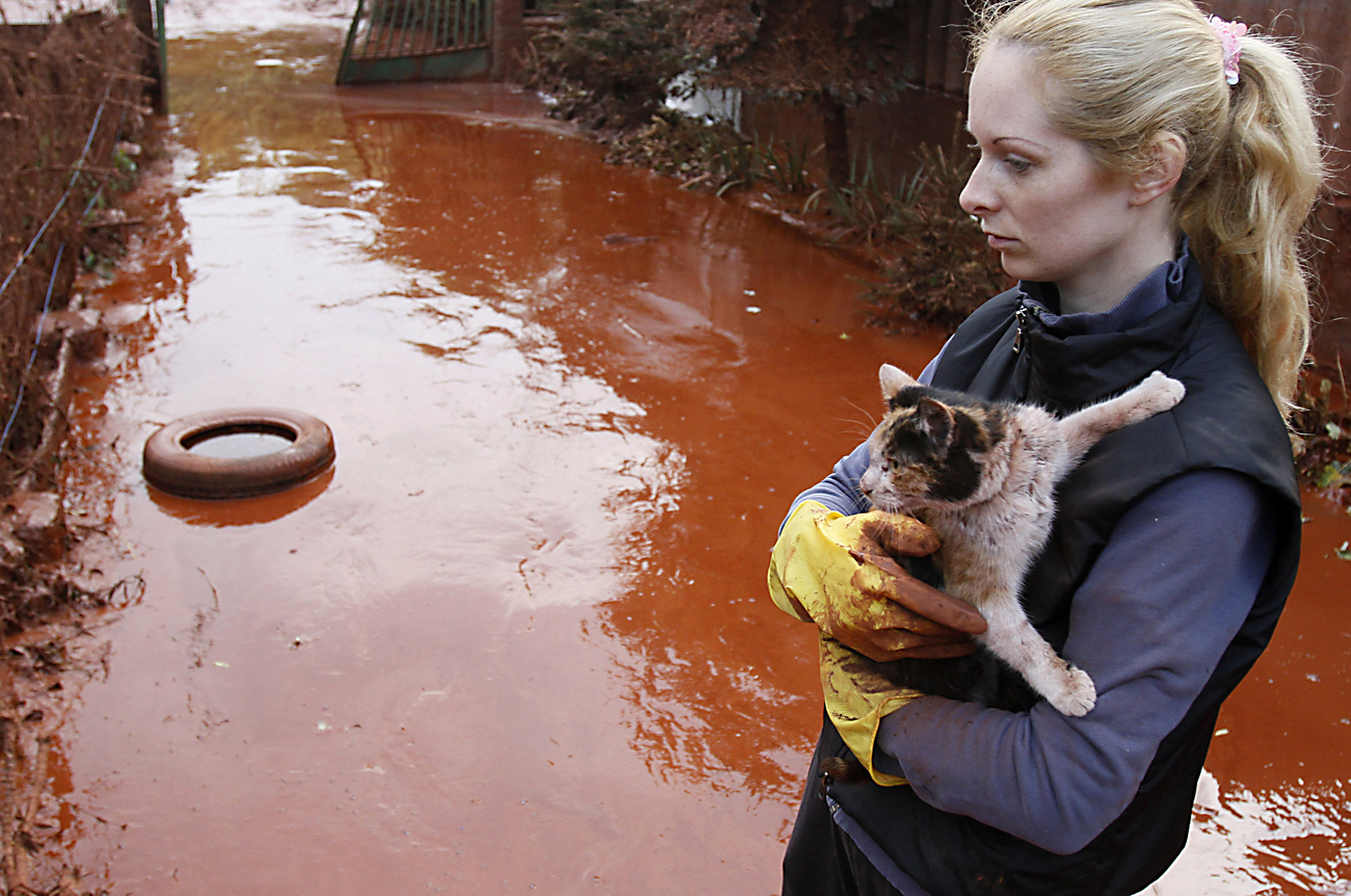 A resident rescues a cat from toxic sludge that flooded the village of Devecser