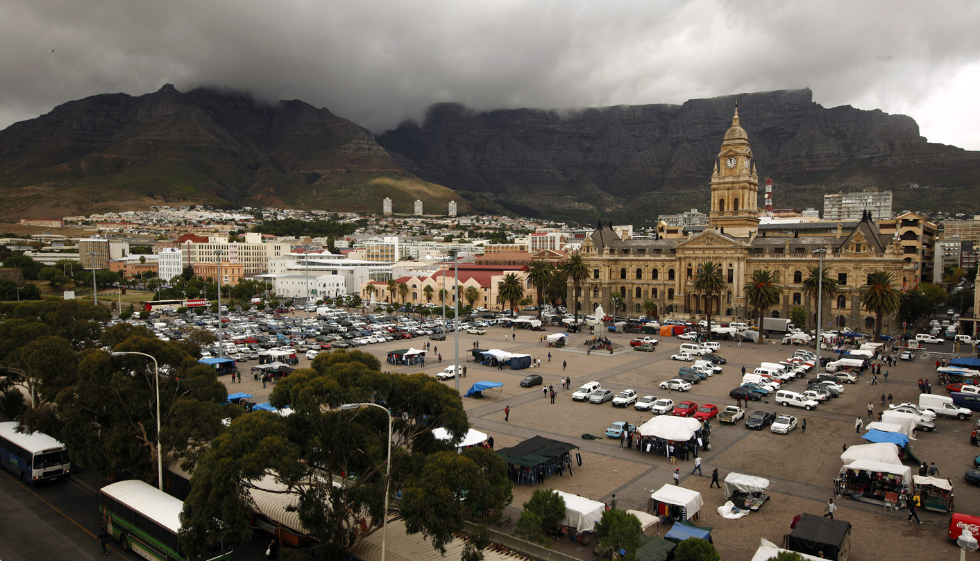 Cape Town's iconic Table Mountain looms behind the City Hall as the clock strikes noon above informal traders at the city's Grand Parade