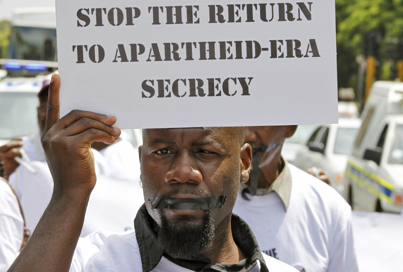 A protester holds a placard as he takes part in a silent march in Johannesburg