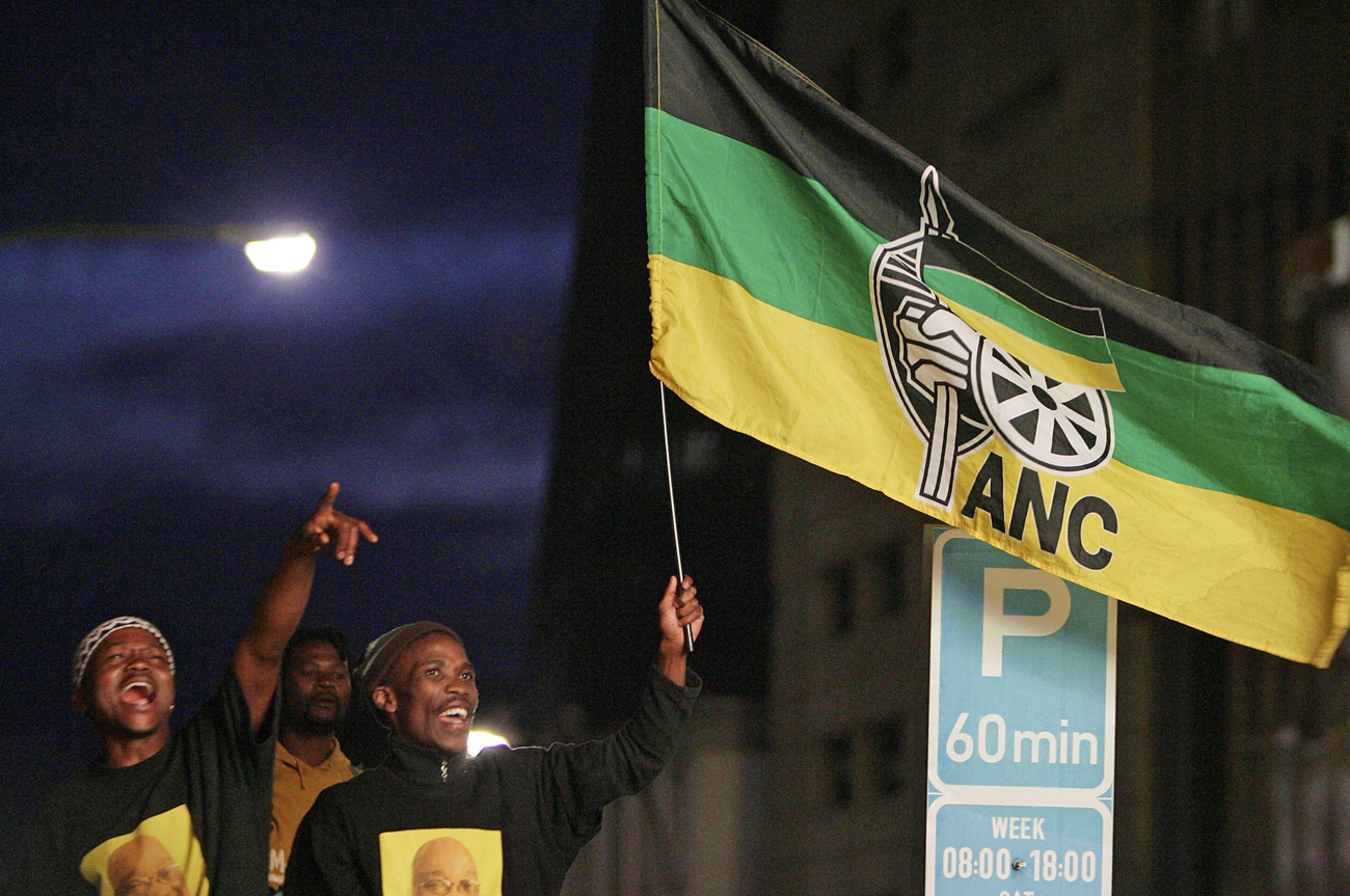 African National Congress supporters carry a flag during their celebration in Johannesburg