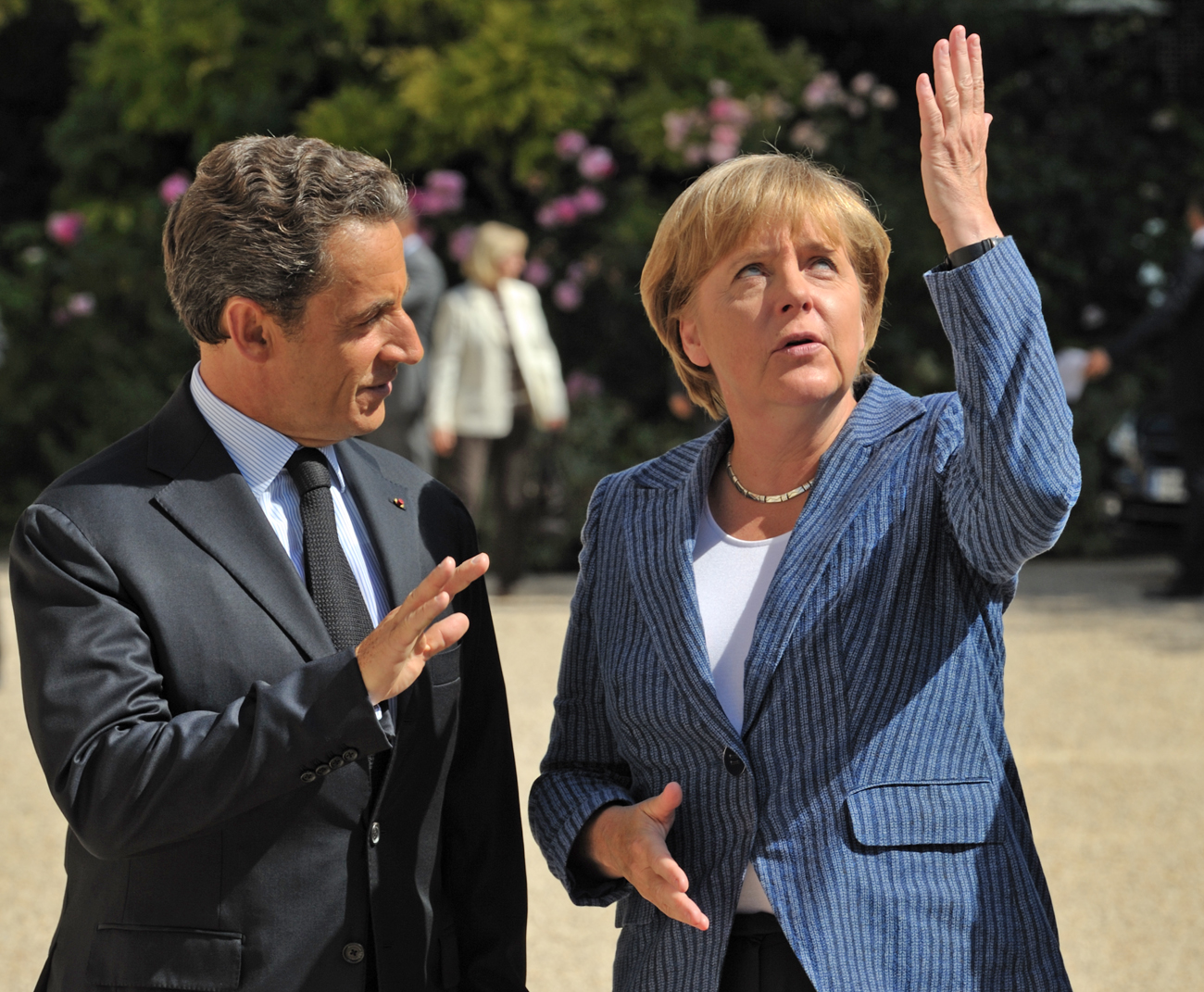 France's President Nicolas Sarkozy welcomes German Chancellor Angela Merkel as she arrives for a meeting at the Elysee Palace in Paris