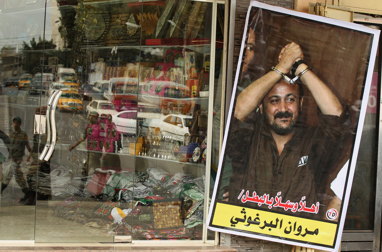 Members of Hamas national security forces are reflected in a souvenir shop window as they patrol a street to celebrate a prisoner swap between Hamas and Israel in Gaza