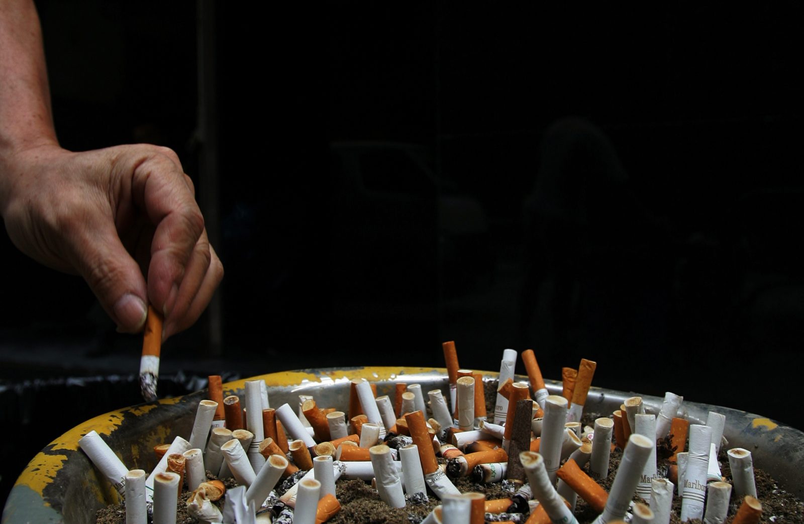 A man discards a cigarette butt outside a construction site in Central