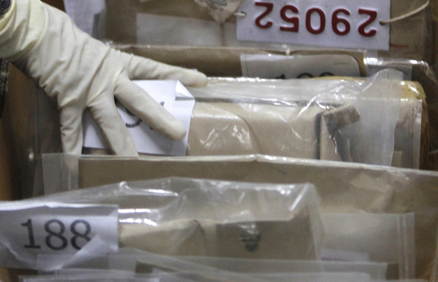 Thai narcotics officials check boxes of confiscated drugs in Bangkok