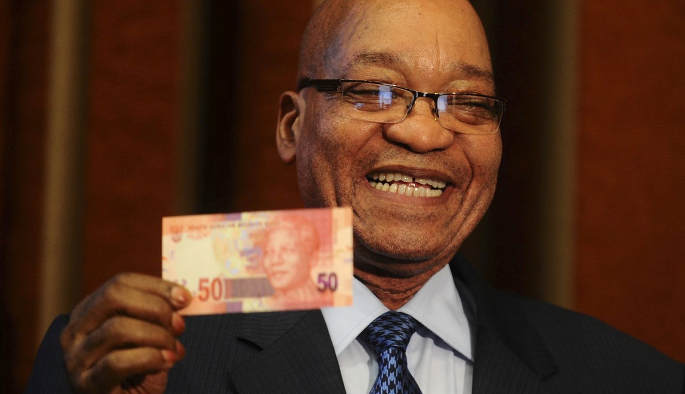 South Africa's President Jacob Zuma holds up a banknote bearing the face of former president Nelson Mandela in Pretoria