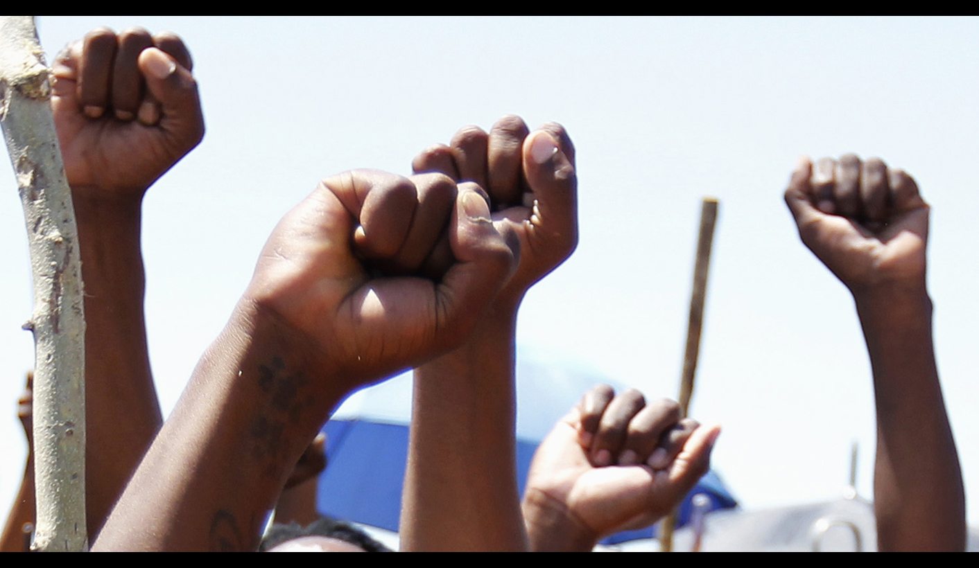 Miners on strike chant slogans as they wait for suspended ANC Youth League President Julius Malema to address them outside the Impala platinum mine in Rustenburg