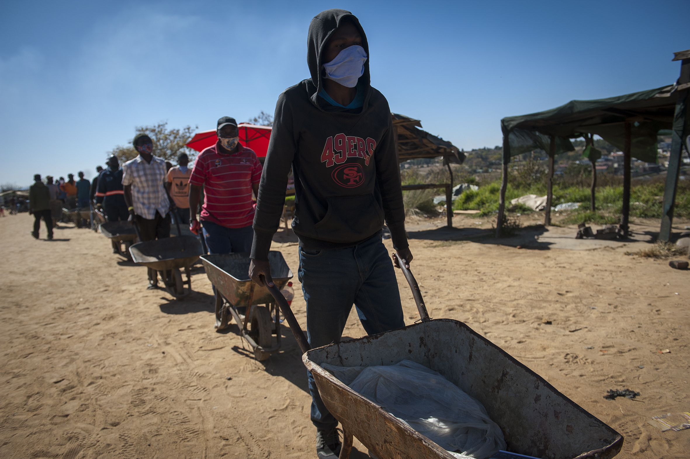 Wheelbarrow agents ferry food to the needy