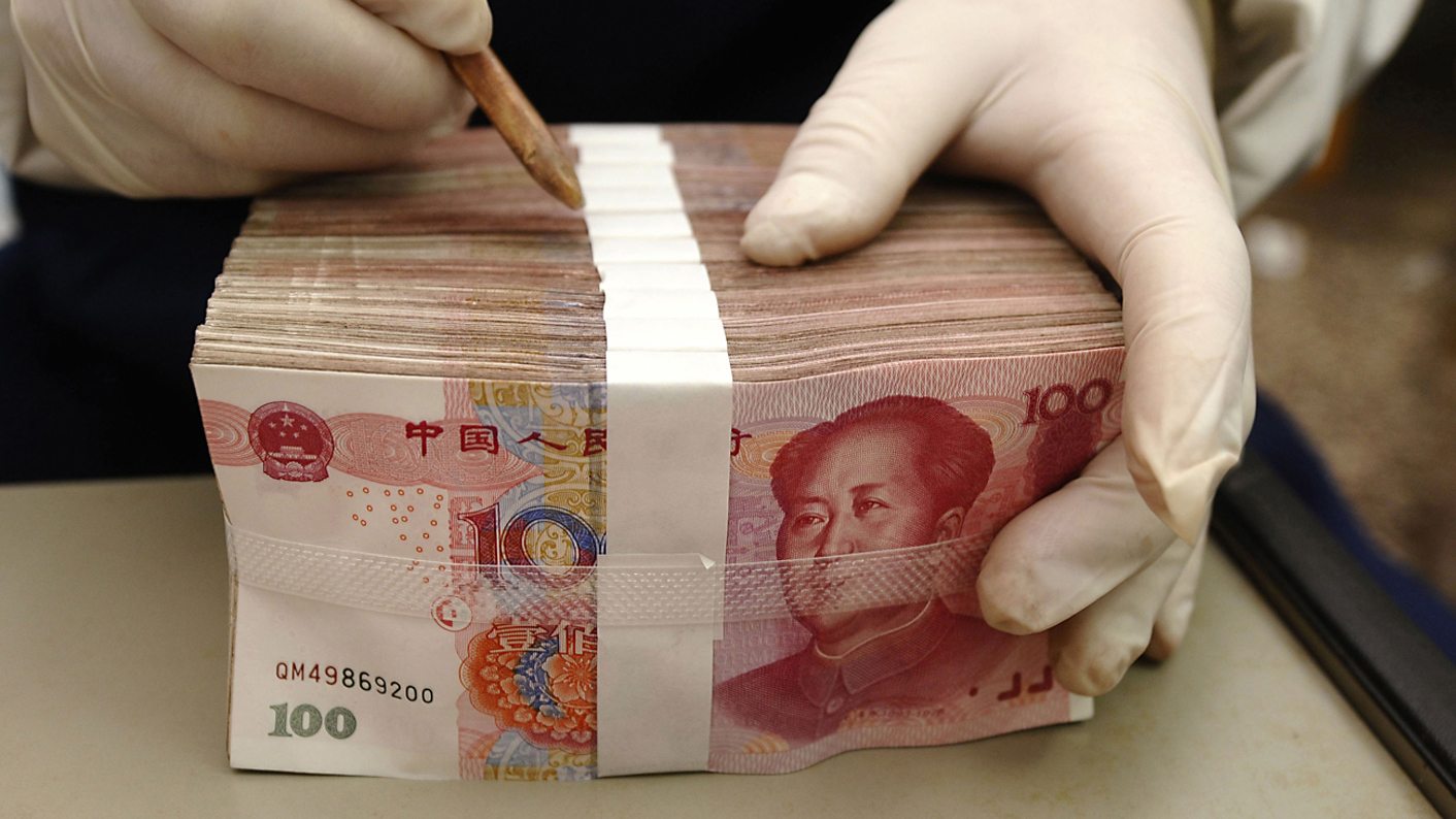 An employee packs yuan banknotes at a branch of Bank of China in Changzhi