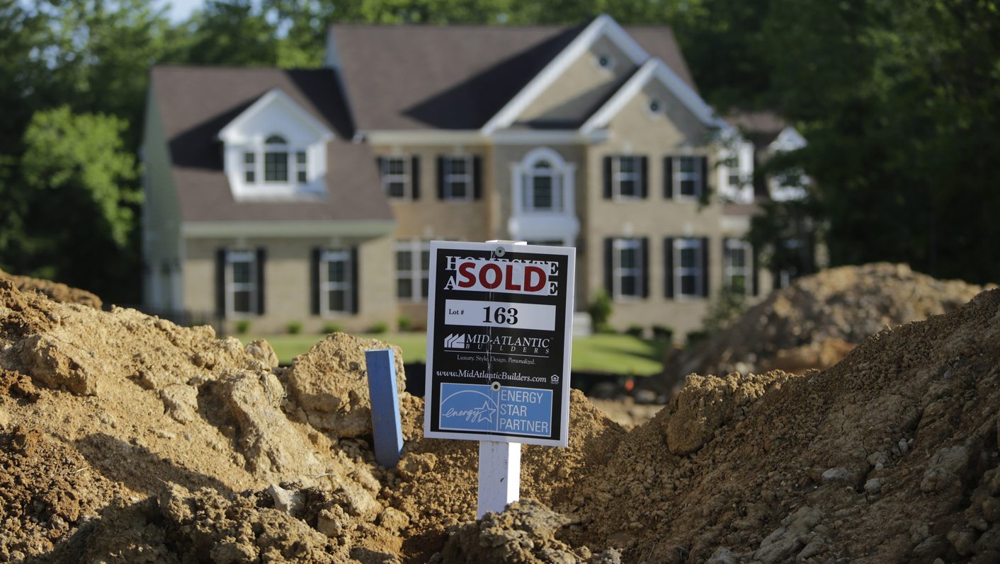 A completed house is seen behind the earthworks of a home currently under construction in Brandywine