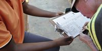 Kgao Johannes Mmangoale signs a register to confirm he has received a food parcel from Macua volunteers. (Photo: Lucas Ledwaba / Mukurukuru Media)