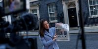LONDON, ENGLAND - JANUARY 13: A TV presenter holds a copy of a newspaper outside 10 Downing Street on January 13, 2022 in London, England. Government Ministers have offered their support to the Prime Minister after he apologised for attending a gathering of colleagues in the Number Ten garden in May 2020, while the UK was in strict lockdown due to the Coronavirus Pandemic. Attendees were invited by Martin Reynolds, Principal Private Secretary to Johnson, asking them to bring their own bottle.  (Photo by Rob Pinney/Getty Images)