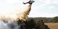 A firefighting helicopter battles a fire outside of Beaufort, Victoria, Australia, 28 February 2024. About 30,000 Victorians have been told to leave their homes as the state braces for catastrophic bushfire conditions.  EPA-EFE/CON CHRONIS AUSTRALIA AND NEW ZEALAND OUT