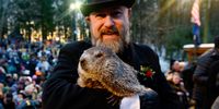 PUNXSUTAWNEY, PA - FEBRUARY 02: Groundhog handler AJ Derume holds Punxsutawney Phil, who saw his shadow, predicting a late spring during the 136th annual Groundhog Day festivities on February 2, 2022 in Punxsutawney, Pennsylvania. Groundhog Day is a popular tradition in the United States and Canada. A crowd of upwards of 5000 people spent a night of revelry awaiting the sunrise and the groundhog's exit from his winter den. If Punxsutawney Phil sees his shadow he regards it as an omen of six more weeks of bad weather and returns to his den. Early spring arrives if he does not see his shadow, causing Phil to remain above ground.  (Photo by Jeff Swensen/Getty Images)